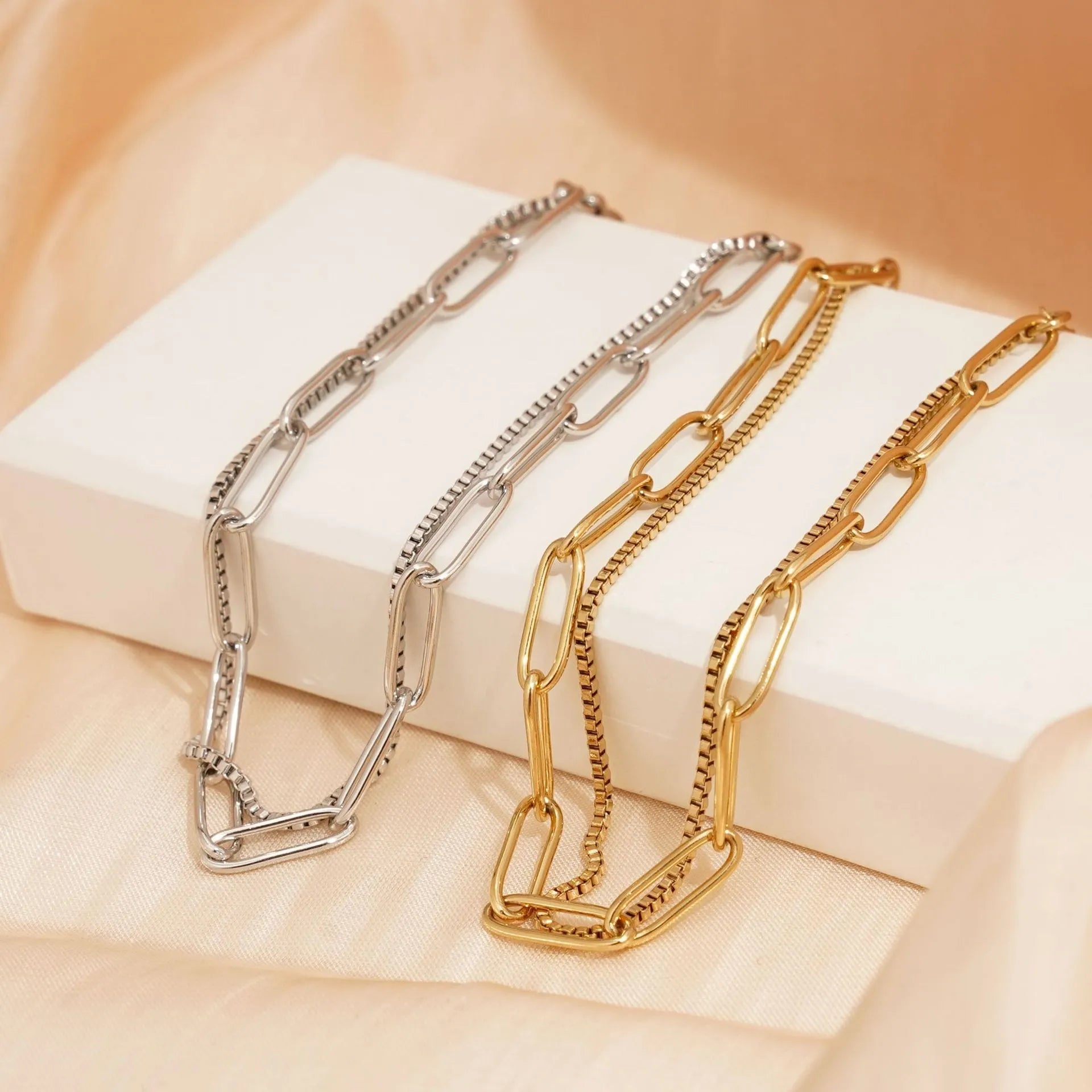 Gold titanium steel electroplated women's bracelet with geometric double layer chain design.