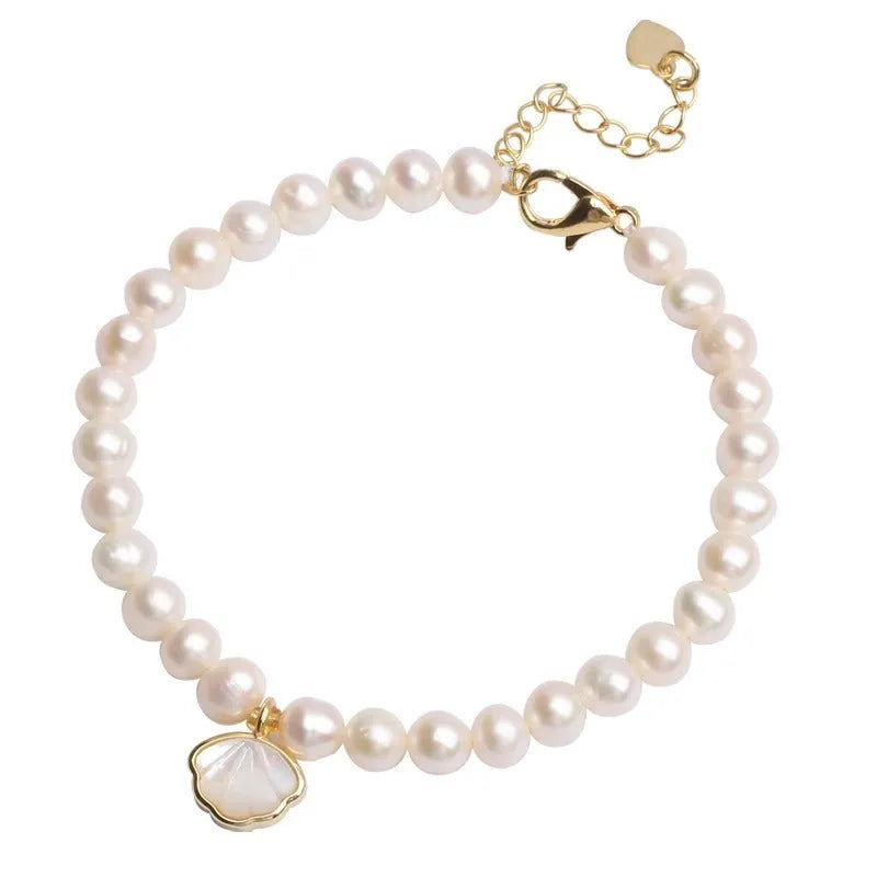 Women's freshwater pearl bracelet with fan-shell alloy clasp in 16cm size on wrist.