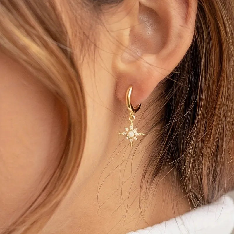 Gold copper eight-pointed star opal stud earrings on a white background