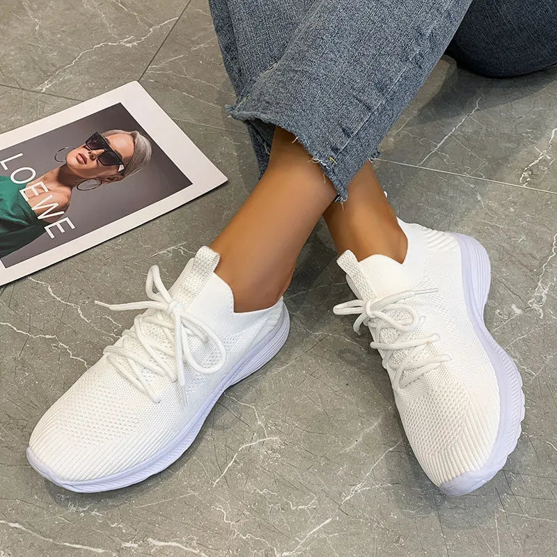 Women's creamy white Flyknit running shoes with mesh lining and low-top design on a rubber sole