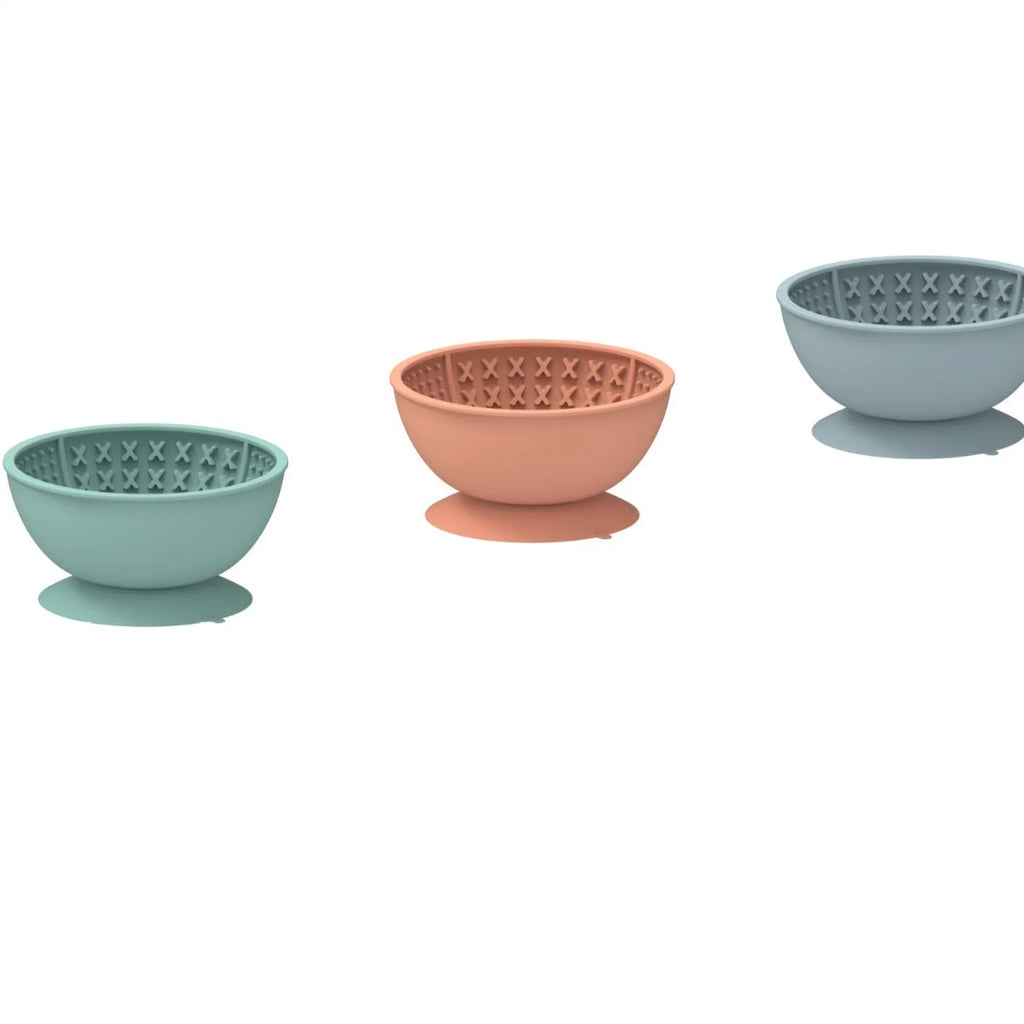 Cyan silicone dog bowl with licking mat texture and suction cup base on a floor.