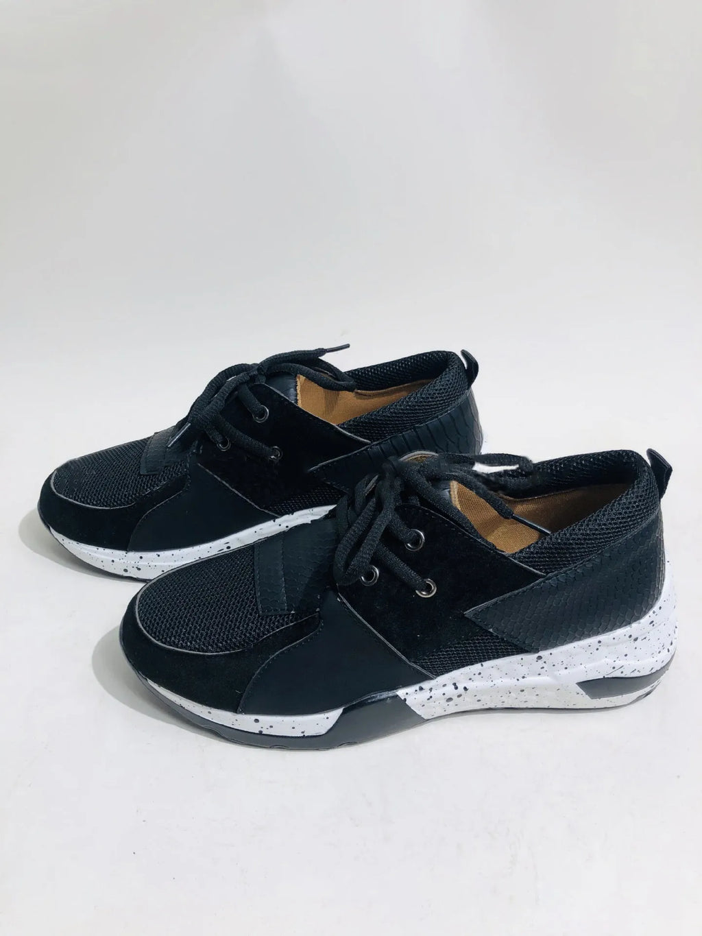 Women's black suede casual sneakers with a wedge heel and round toe on a light background.