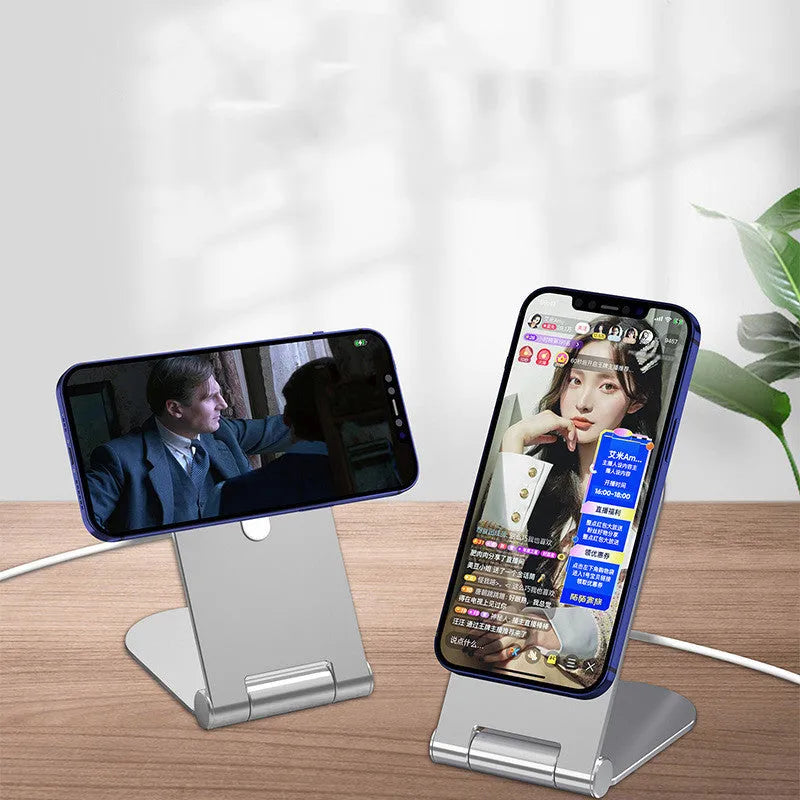 Silver vertical adjustable magnetic phone bracket for iPhone 12 series on a desk.