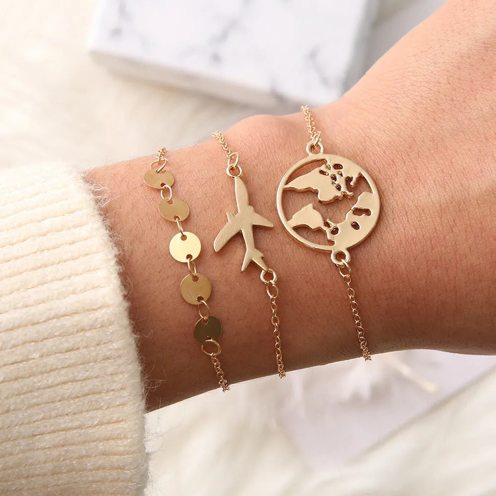 Three silver-tone alloy bracelets with heart-shaped charms featuring aircraft and map designs.