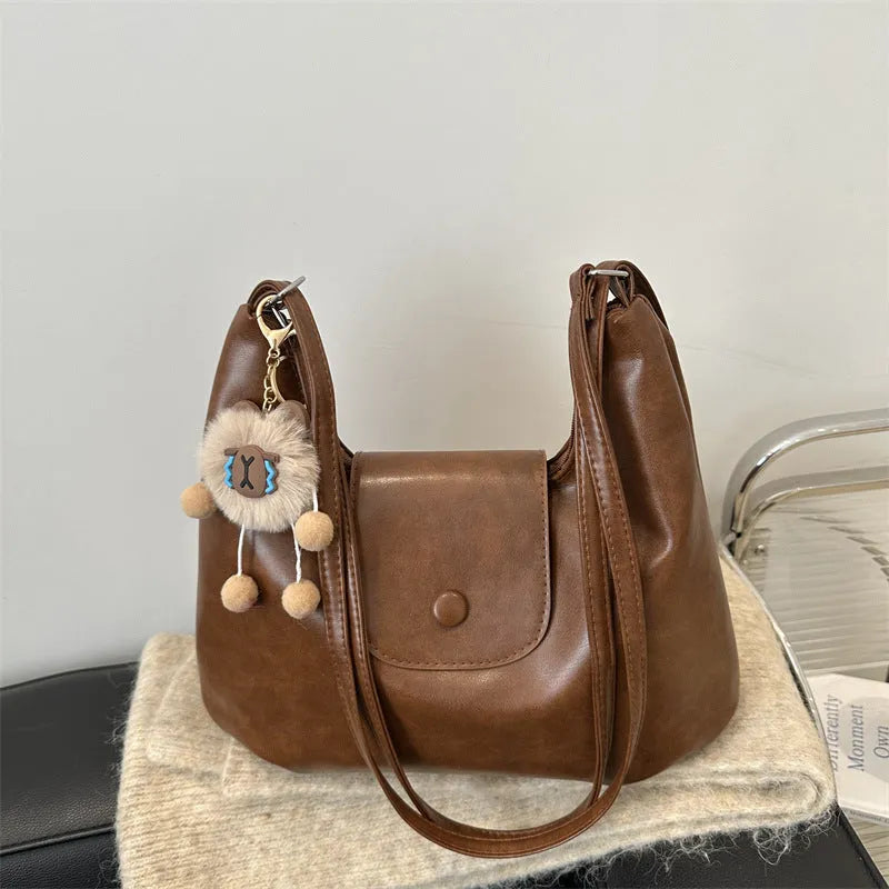 Women's PU leather commuter shoulder bag in horizontal square shape with single strap and optional pendant