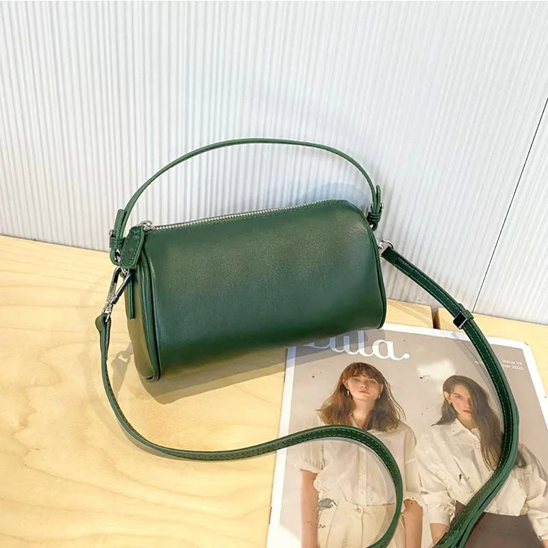 Soft genuine leather cylindrical crossbody bag for mobile phones, shown in a street style with visible stitching.