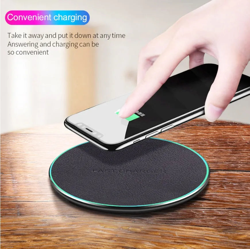 Black Quick Qi wireless charging pad for iPhone 11 on a desk surface