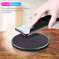 Black Quick Qi wireless charging pad for iPhone 11 on a desk surface