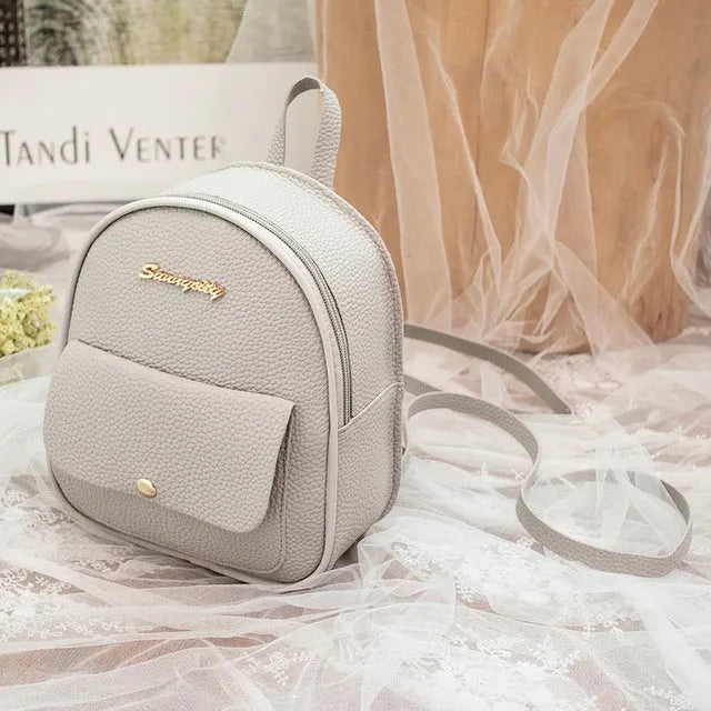 Compact black PU women's shoulder bag also worn as a small backpack, showing zipper closure.