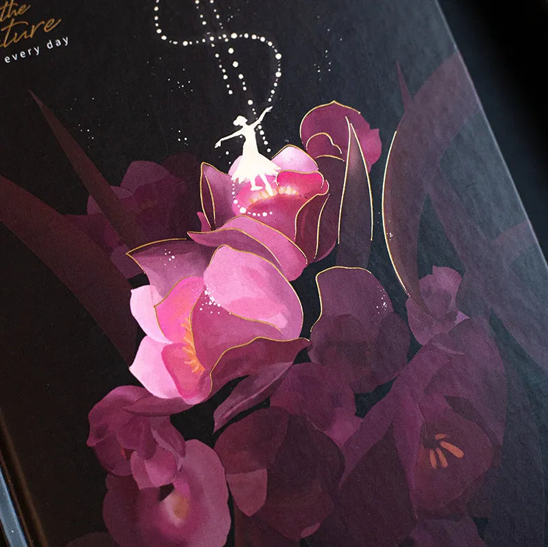 A5 notebook with a luminous cover open to show internal colour illustrations, next to Purple, Light Blue, Gold, and Deep Blue colour options.