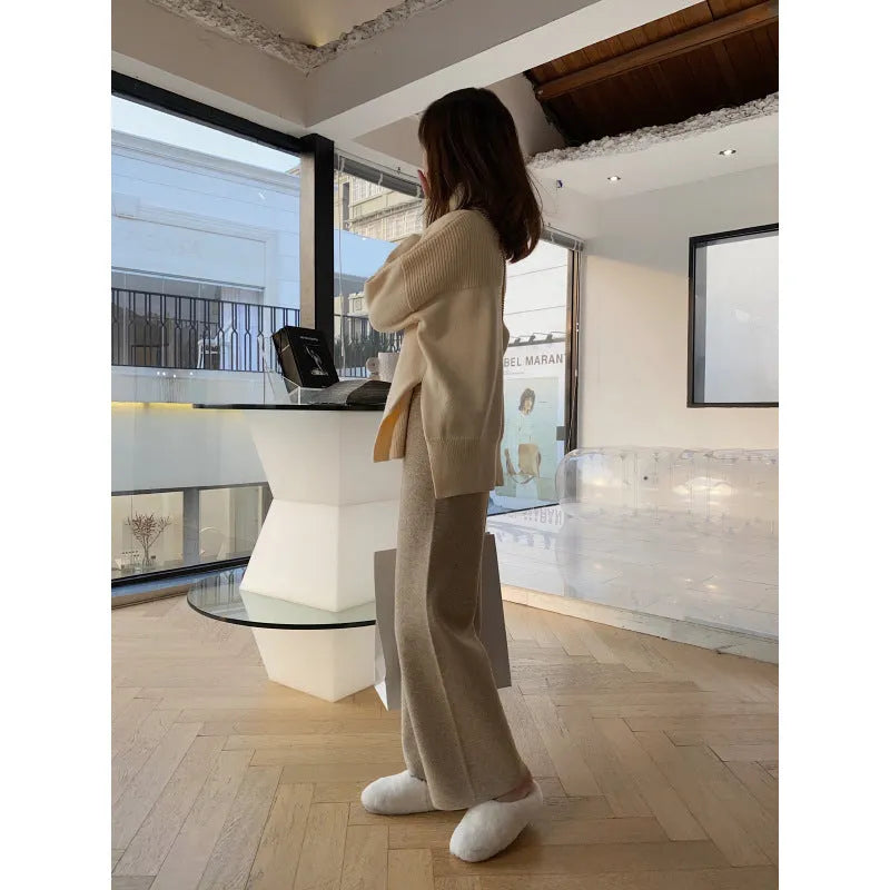 Woman wearing high waist cream white knitted wide-leg trousers with a straight, drooping mopping cut.