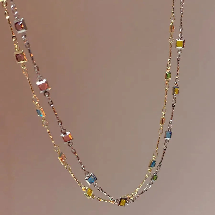 Square artificial crystal pendant on a fine gold clavicle chain necklace.