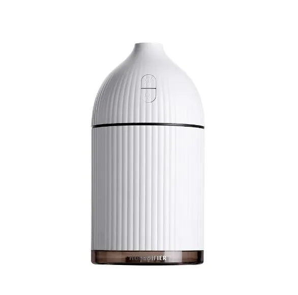 White ultrasonic aromatherapy diffuser and humidifier with LED light on a wooden surface.