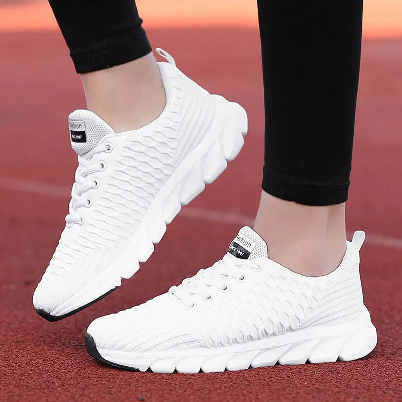 Women's fly knit running shoes in black, pink, or white colours, showing the woven upper and durable outsole.