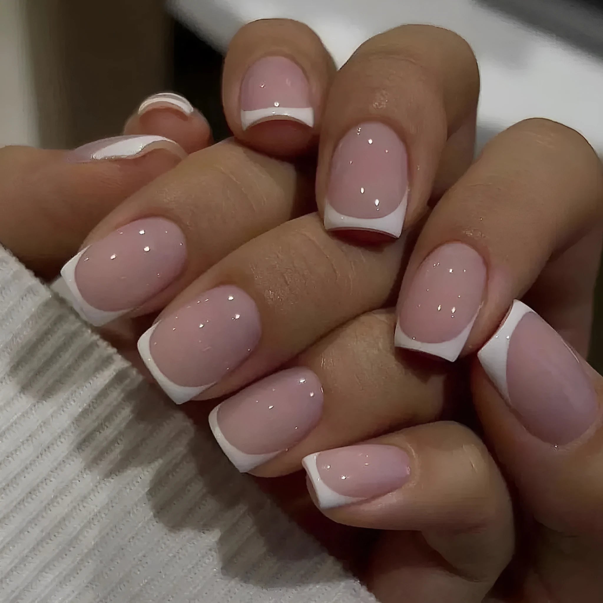 24 white plaid-pattern false nail tips laid out on a surface