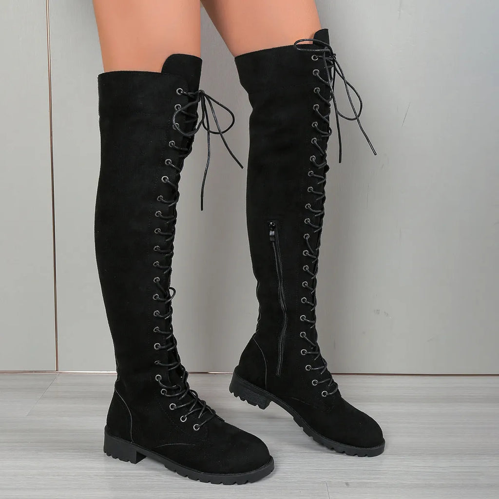 Black over-the-knee lace-up boots with round toe, flat rubber sole, and visible stitching details