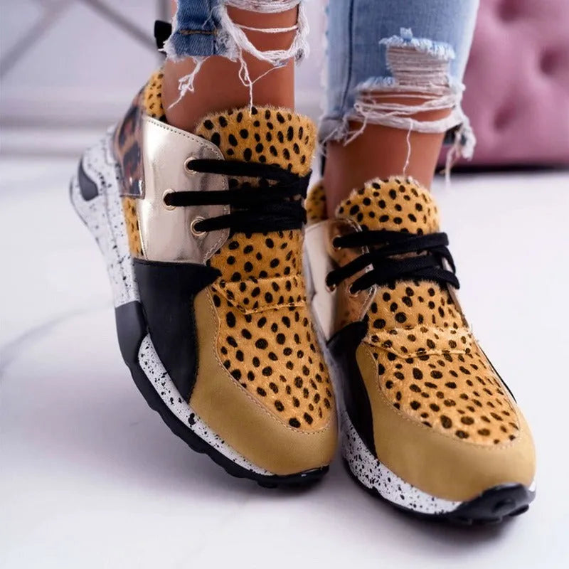 Women's black suede casual sneakers with a wedge heel and round toe on a light background.