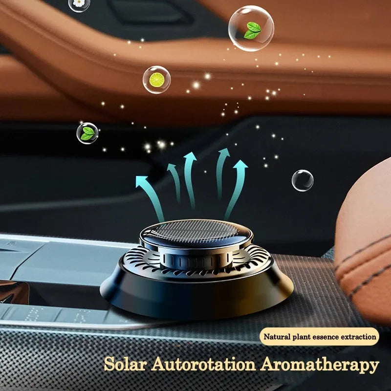 Solar powered kinetic car air freshener with rotating double rings on vehicle dashboard