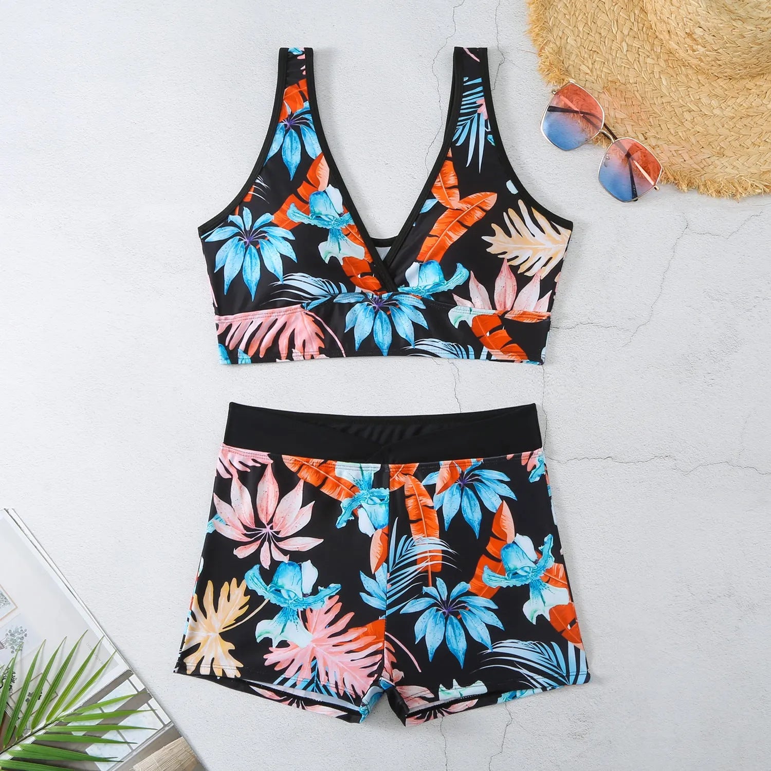 Women's two-piece swimsuit set with sleeveless top and printed boxer-style bottoms in a multi-colour pattern.