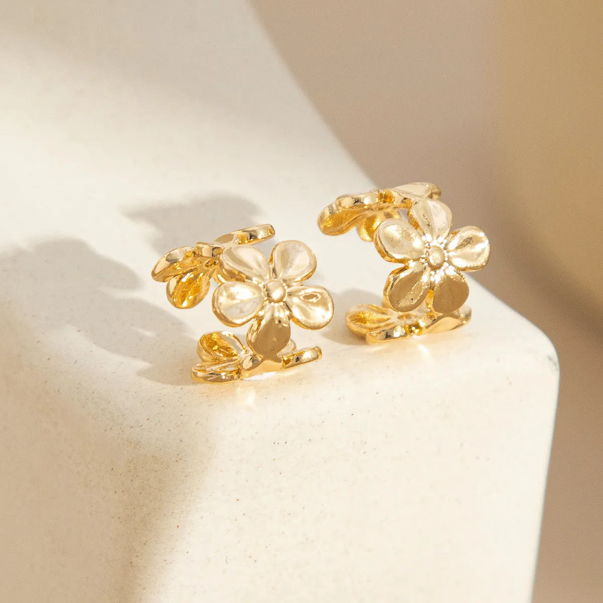 Gold-coloured women's earrings with conch and starfish beach-themed decorative elements