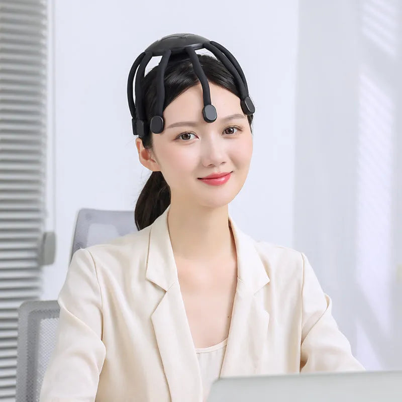 Black USB-powered head massager with multiple claws placed on a scalp