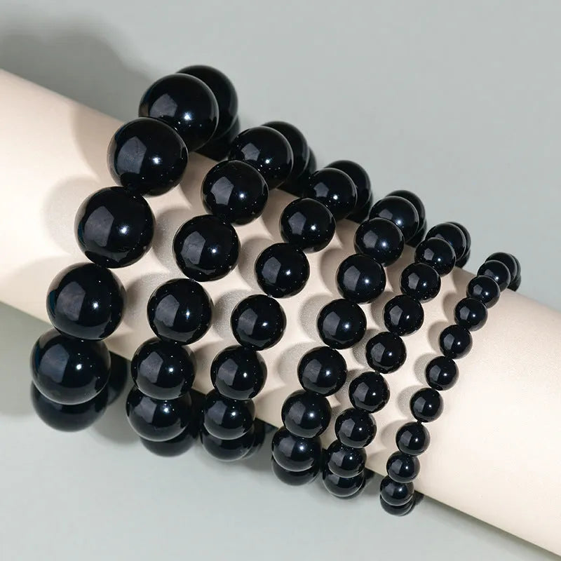 Hand-woven obsidian bracelet with round beads and engraved birth year detail for couples