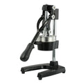 A black cast iron manual citrus juicer with a stainless steel strainer on a kitchen counter.