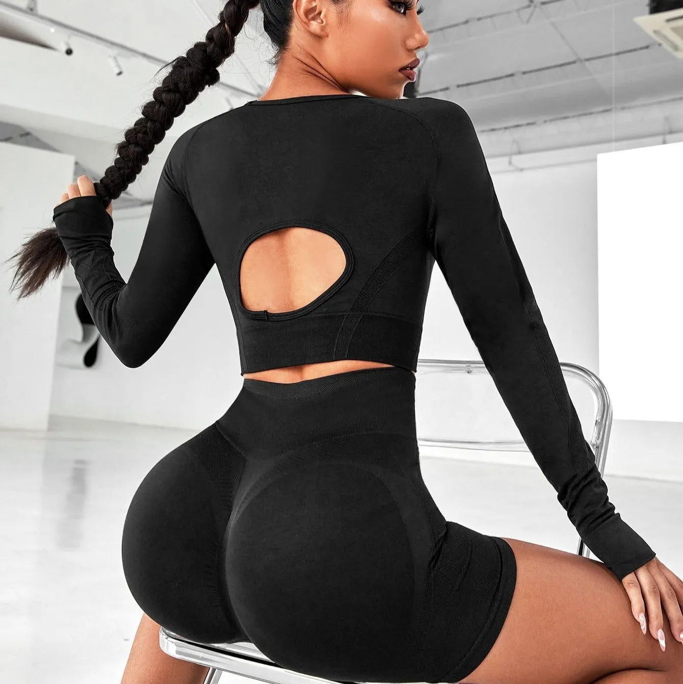 Women's high-waist yoga suit in black, featuring a long sleeve top and tight-fit trousers.