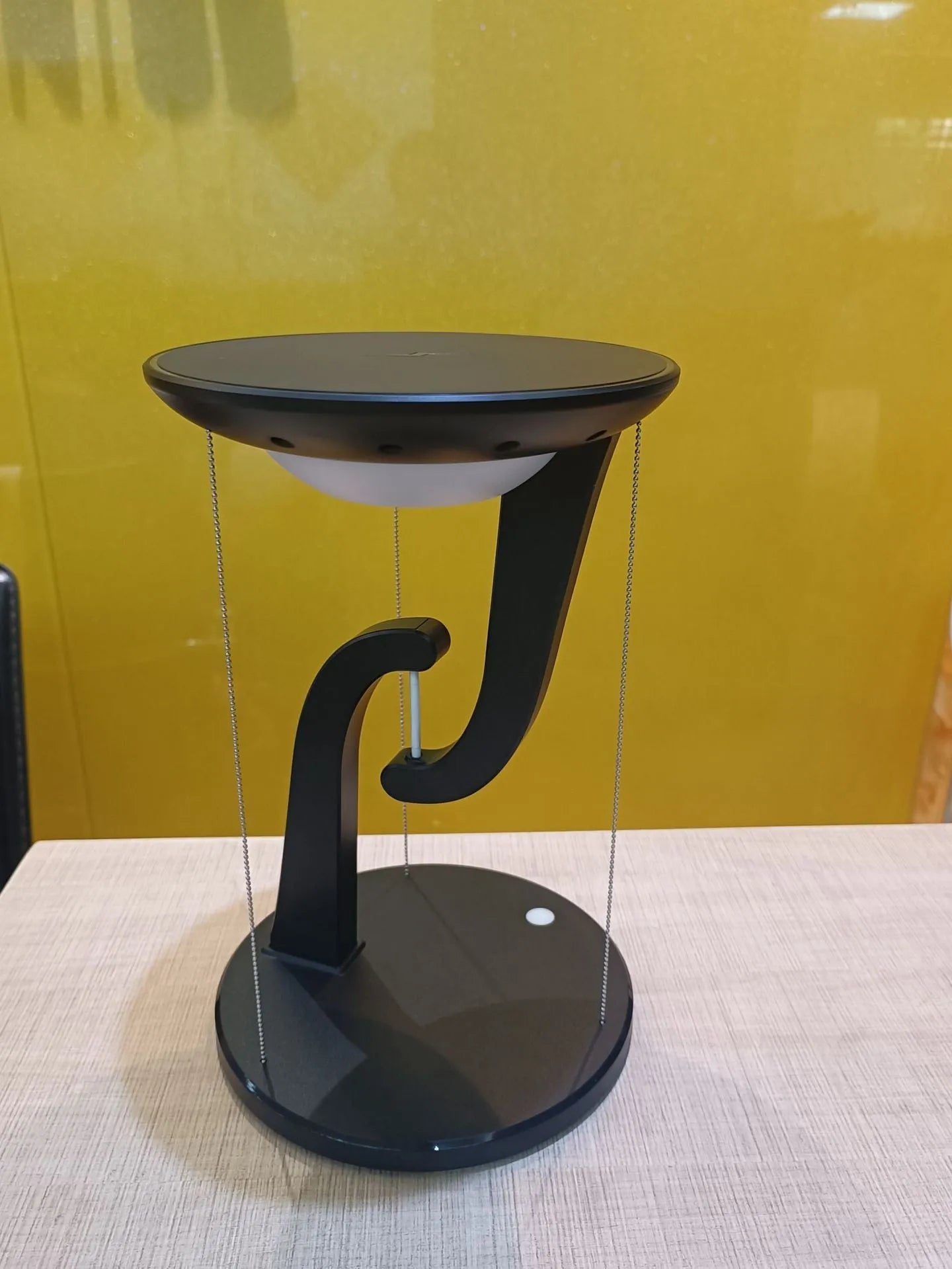 White creative smart wireless phone charger suspension lamp on desk with USB cable