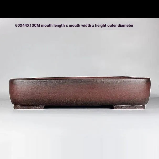 Handmade antique rectangular purple clay flower pot on tabletop