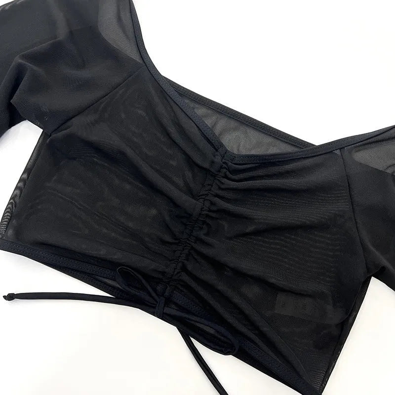 Black mesh women's four-piece bikini set with long sleeve top on a mannequin