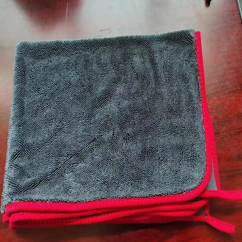 Grey car cleaning towel with red edge trim showing braid twisted texture for automotive glass washing
