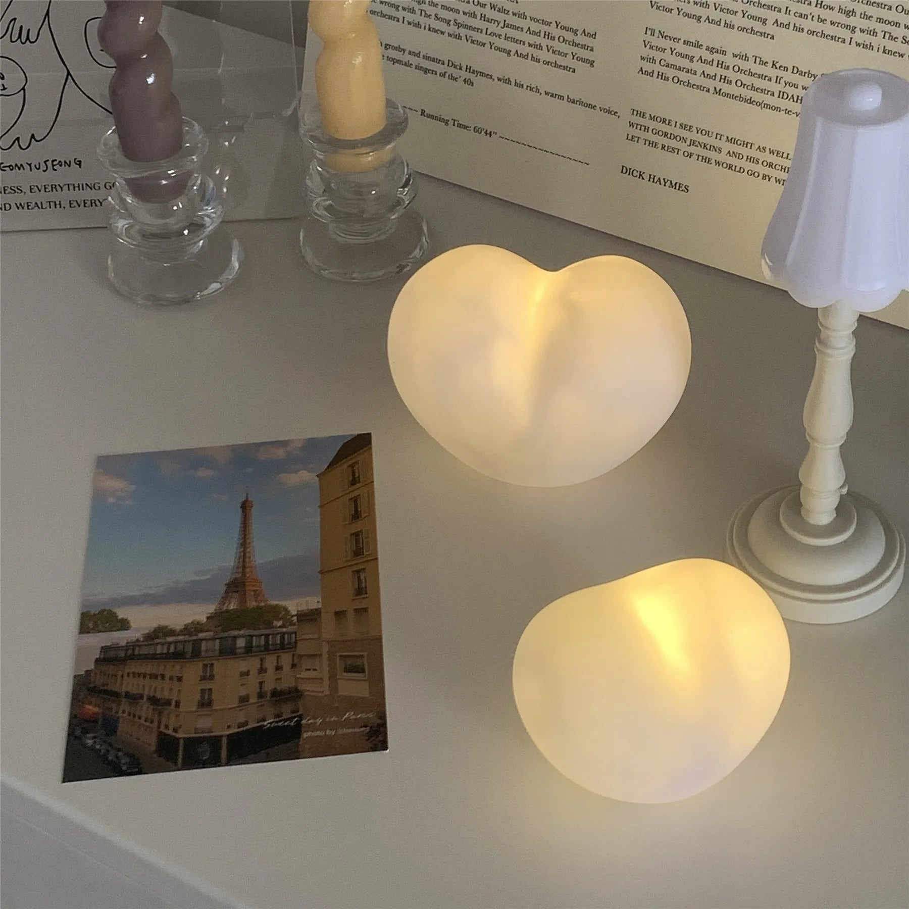 Small white vinyl atmosphere lamp with glowing warm light on a table.