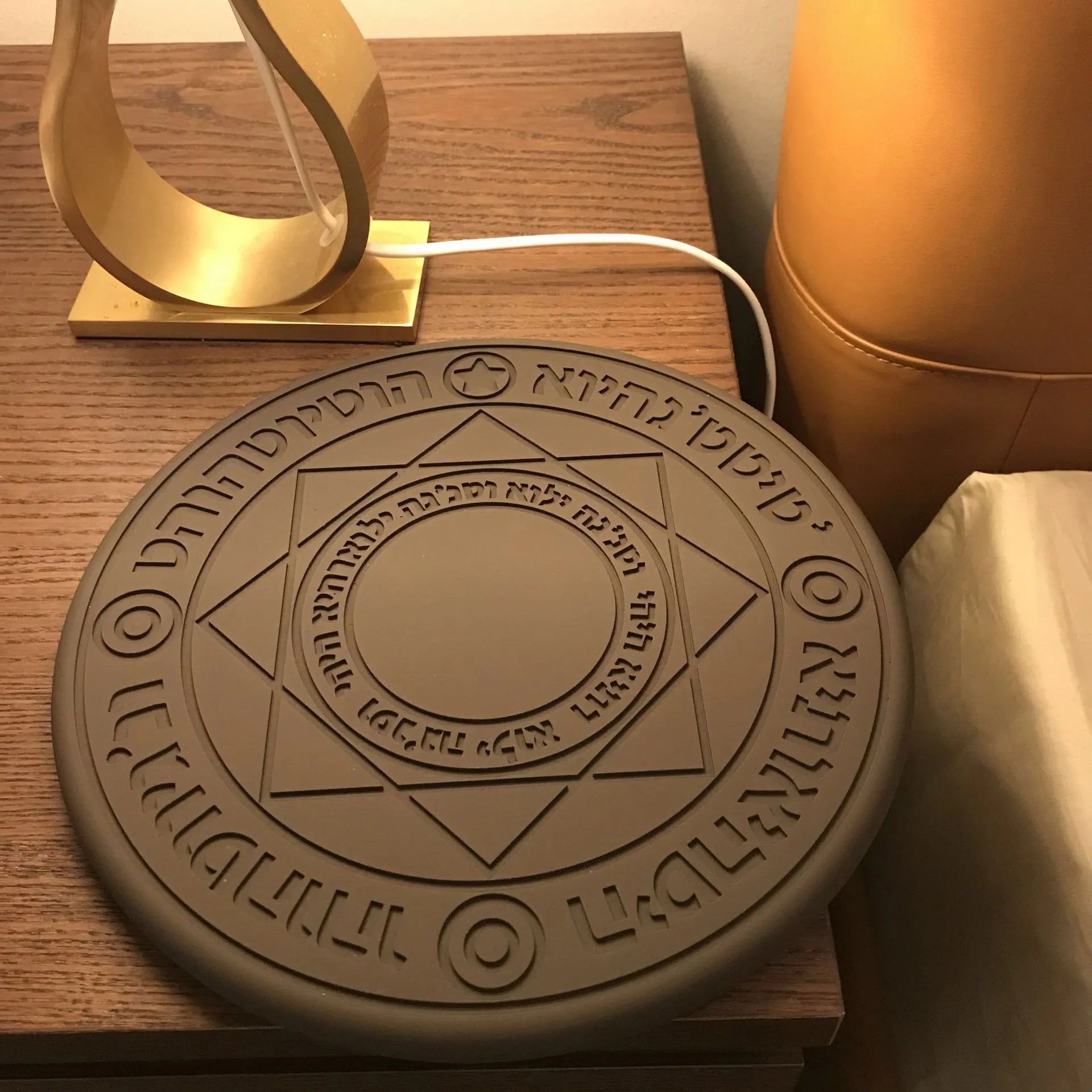 Square wireless phone charger with magic array pattern showing black colour option on desk surface