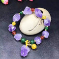 Close-up of a purple natural amethyst bead bracelet with a fu charm for women, on a white background.