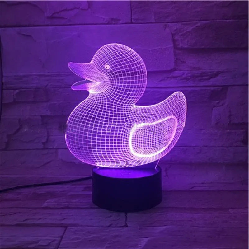 Little Yellow Duck 3D night light showing seven LED colours on a tabletop with remote control.