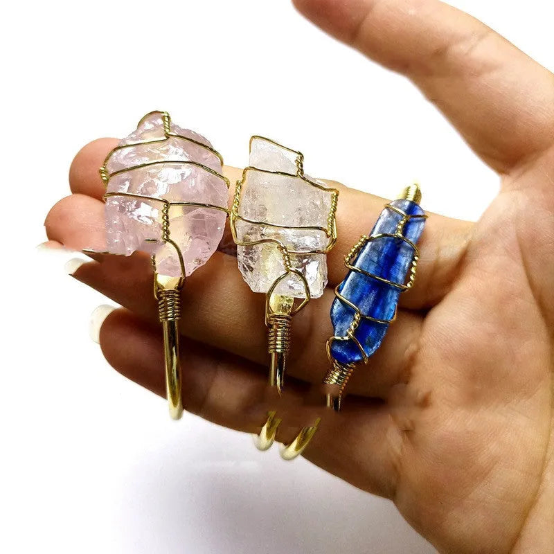 Geometric natural crystal bracelet with gold metal winding on a wrist.