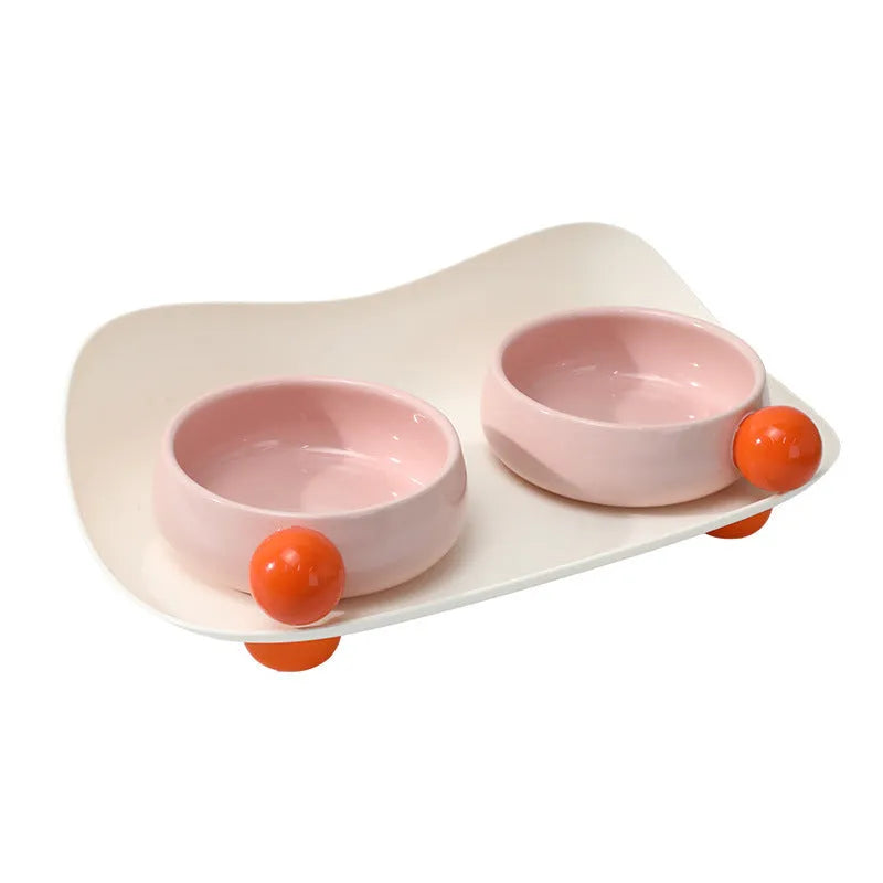 Ceramic raised pet feeding bowl set in pink with two bowls and non-slip base.