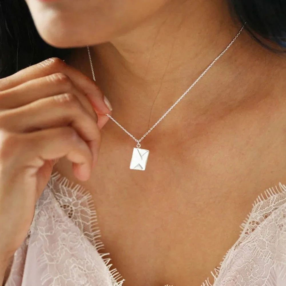 Gold envelope-shaped locket pendant on a stainless steel chain with custom engraving option