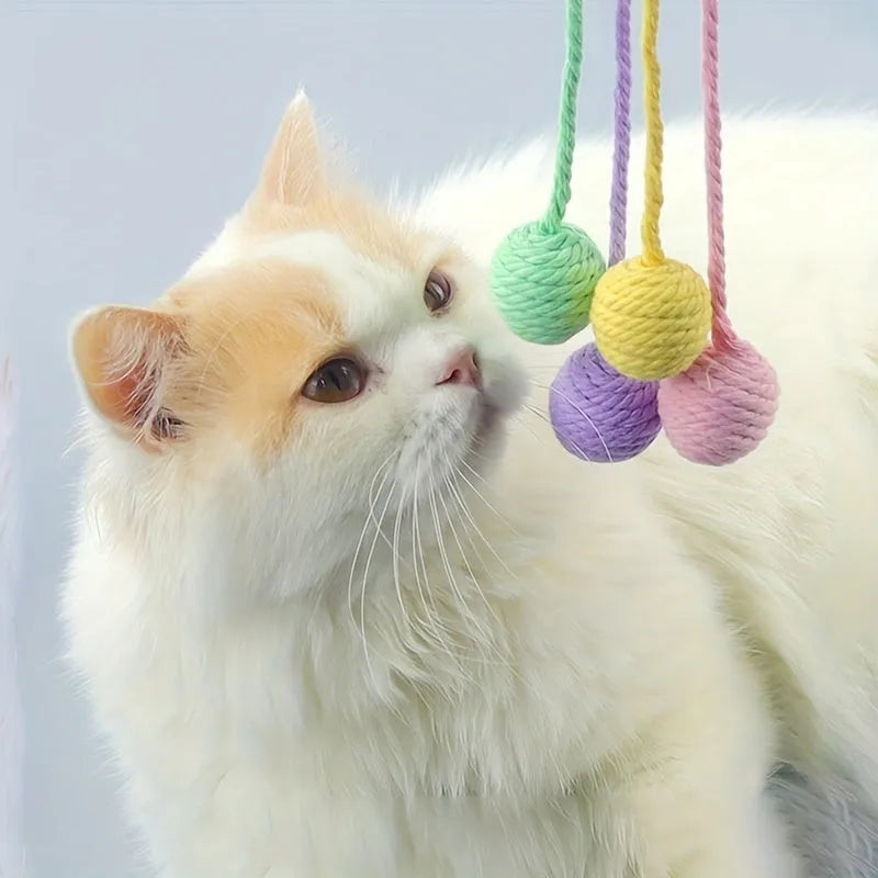 Coloured cat toy ball with rope attached and built-in bell inside, shown in green, pink, purple, and yellow options