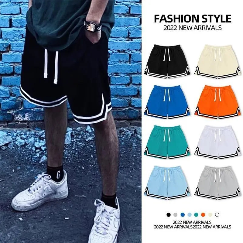 Man wearing loose grey sports shorts made from elastic polyester fabric.