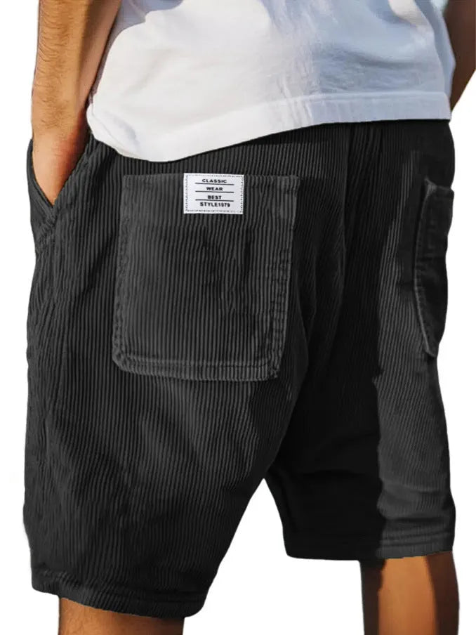 Men's grey corduroy shorts with embroidered detail on multiple pockets, laid flat.