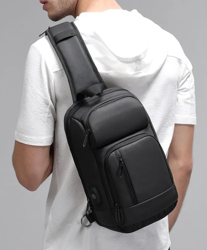 Black PVC outdoor shoulder bag showing internal organisation compartments and air cushion strap