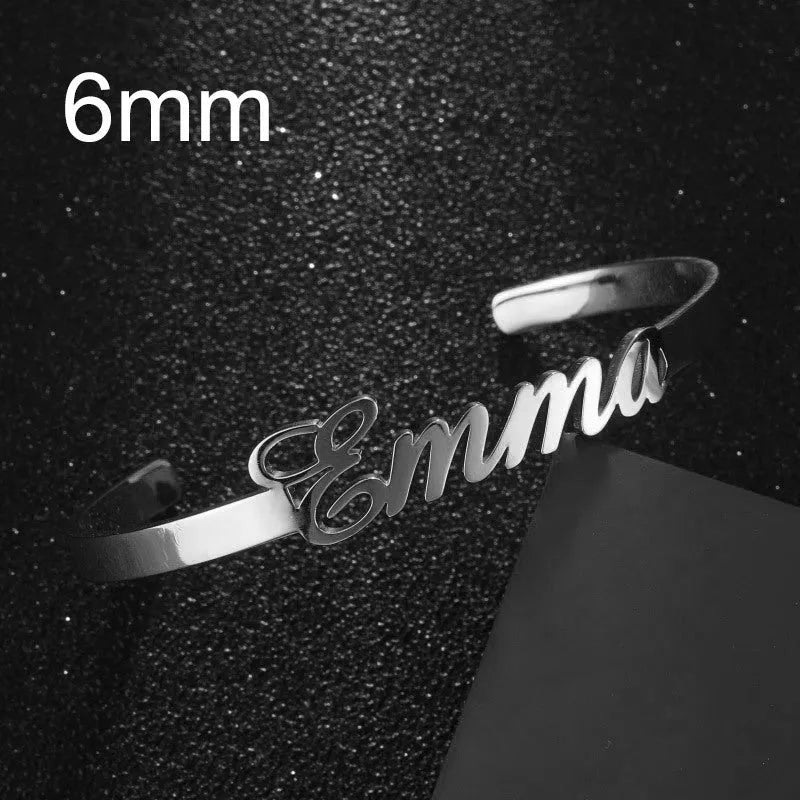 Custom engraved name bangle in stainless steel, silver colour finish, shown on a flat surface