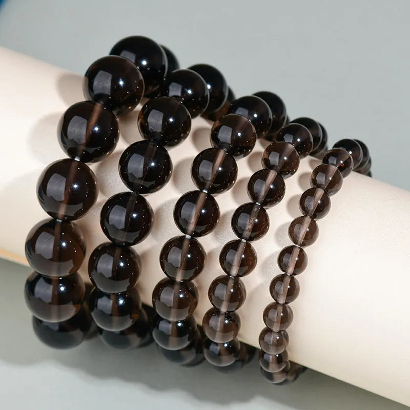 Hand-woven obsidian bracelet with round beads and engraved birth year detail for couples