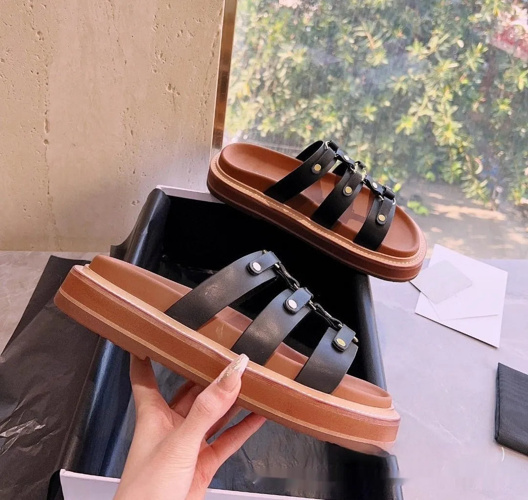 Women's brown patent leather Roman sandal slippers with sheepskin upper on a white background.