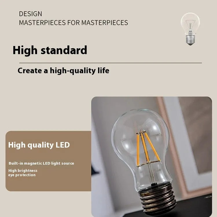 Iron art suspension bulb night lamp on black wood grain base measuring 11cm