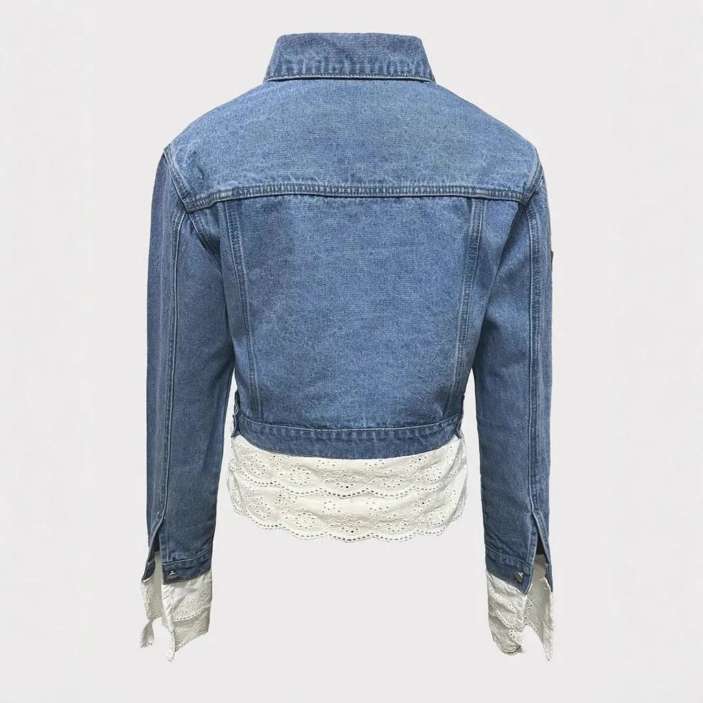Blue women's denim jacket with lace stitching detail on the sleeves and front, featuring long sleeves.