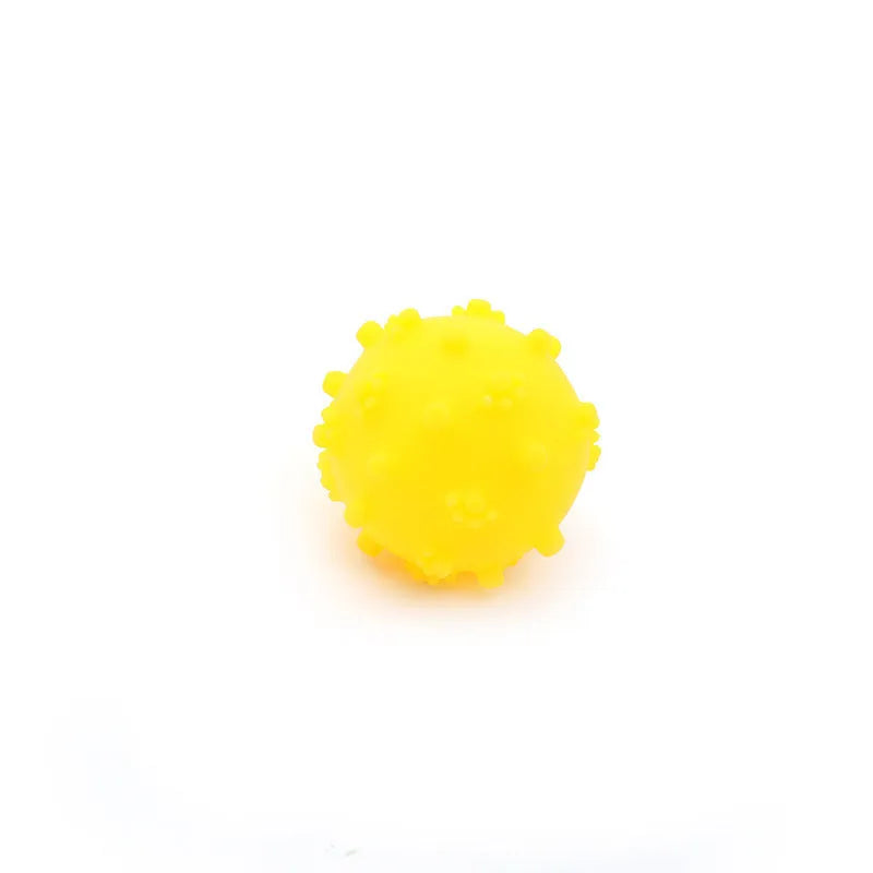 Bright blue, green, pink, and yellow spiked dog toy balls with paw print dimples on a white background.