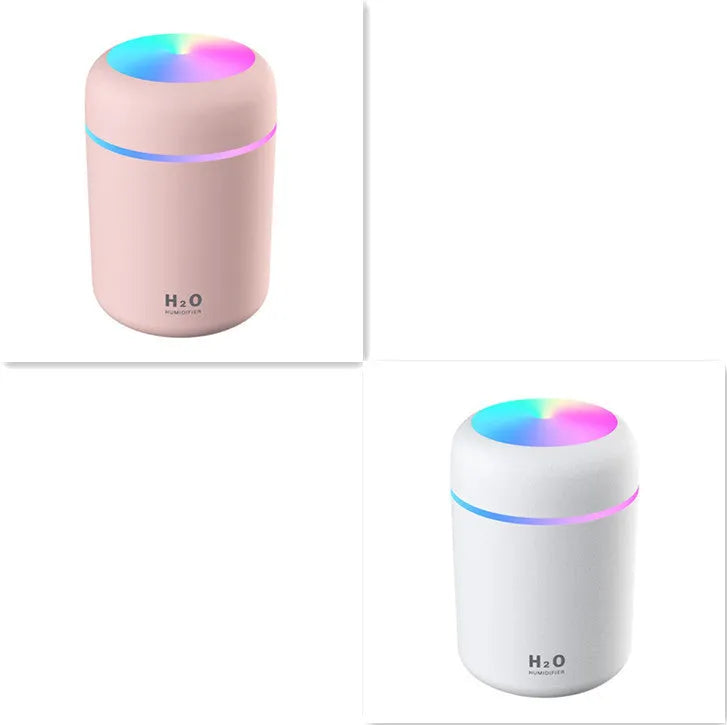 Pink USB mini humidifier with LED lights and water tank on desk